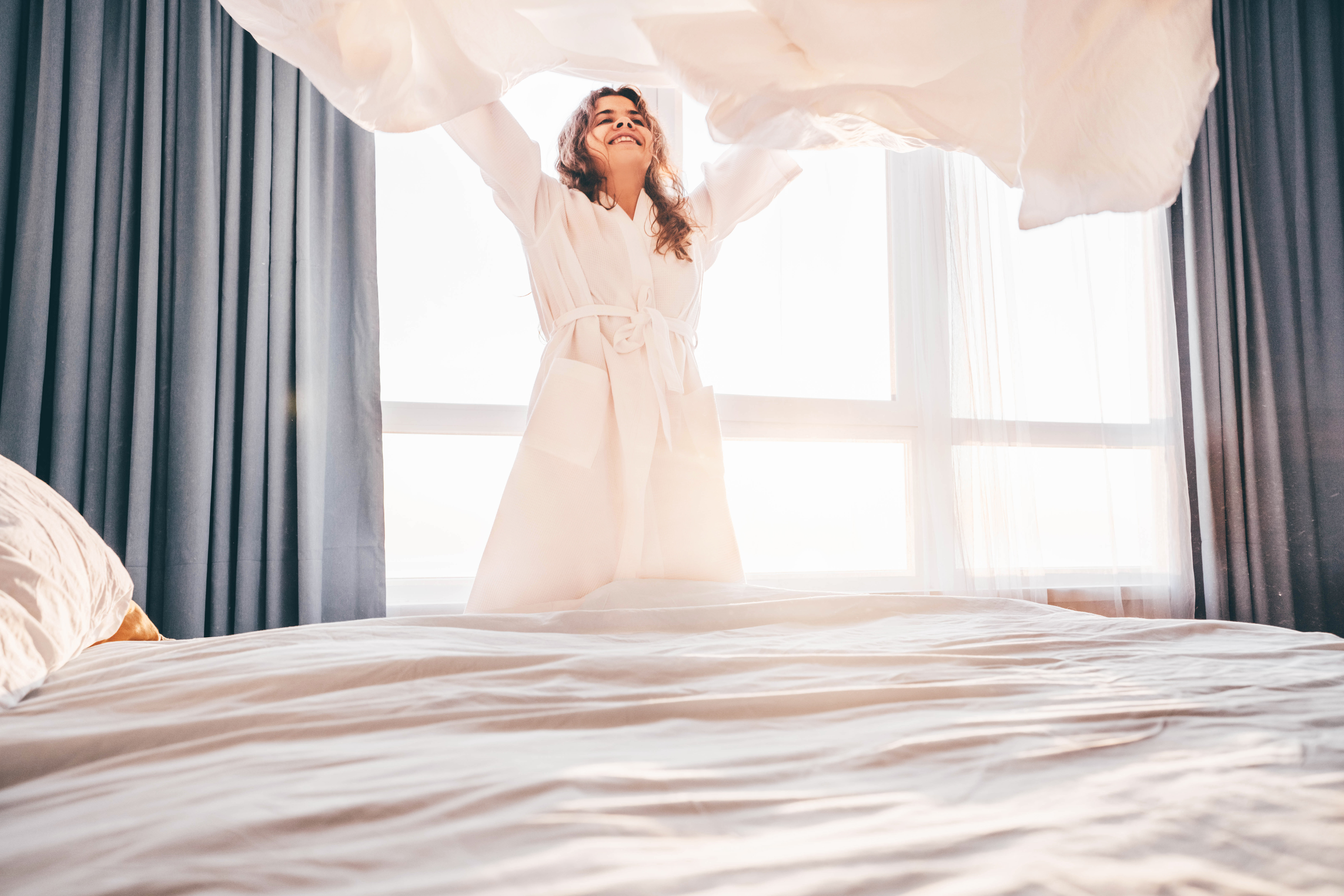 Vrouw die haar bed opmaakt gewassen met wasmiddel