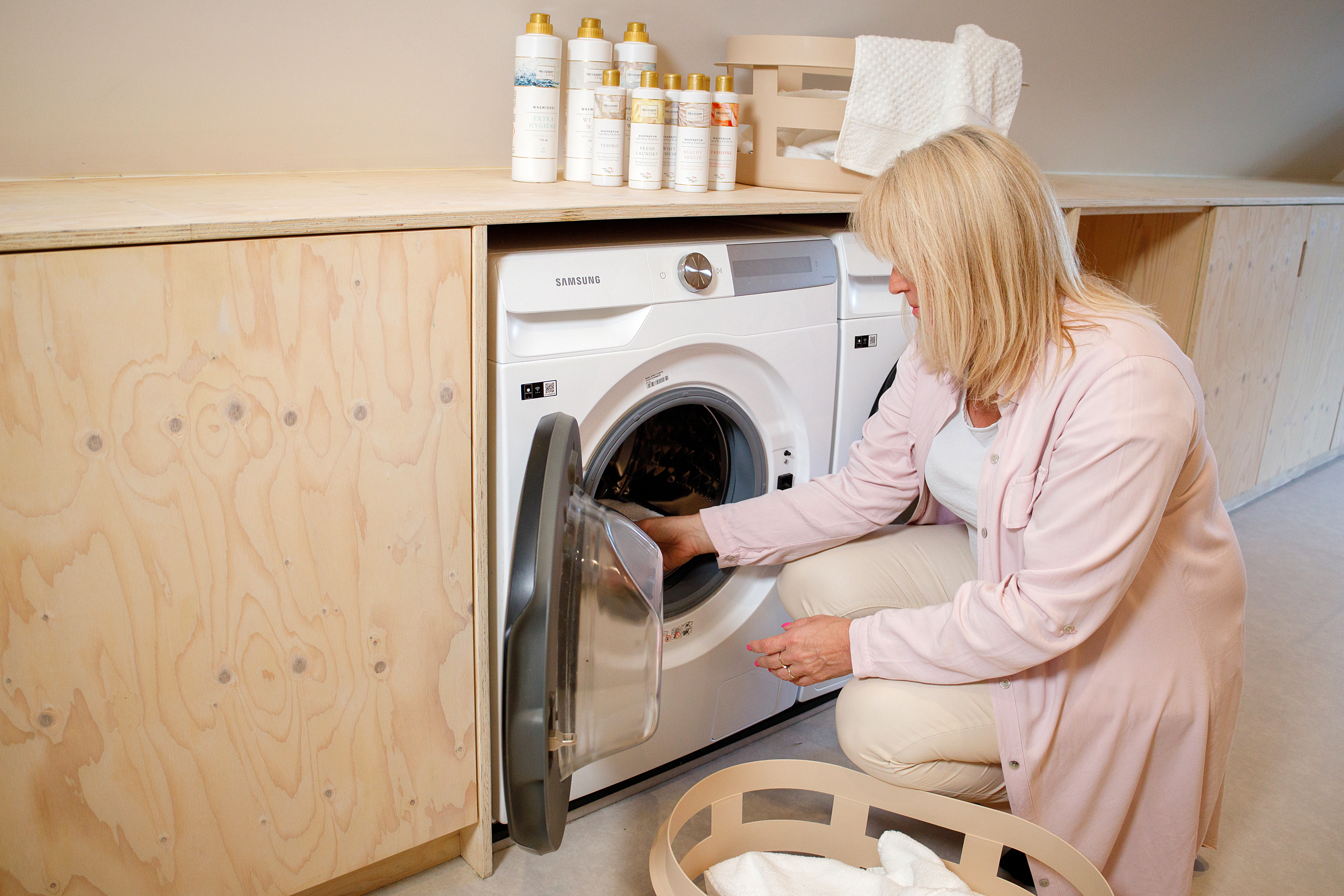 Vrouw die de was in de wasmachine doet