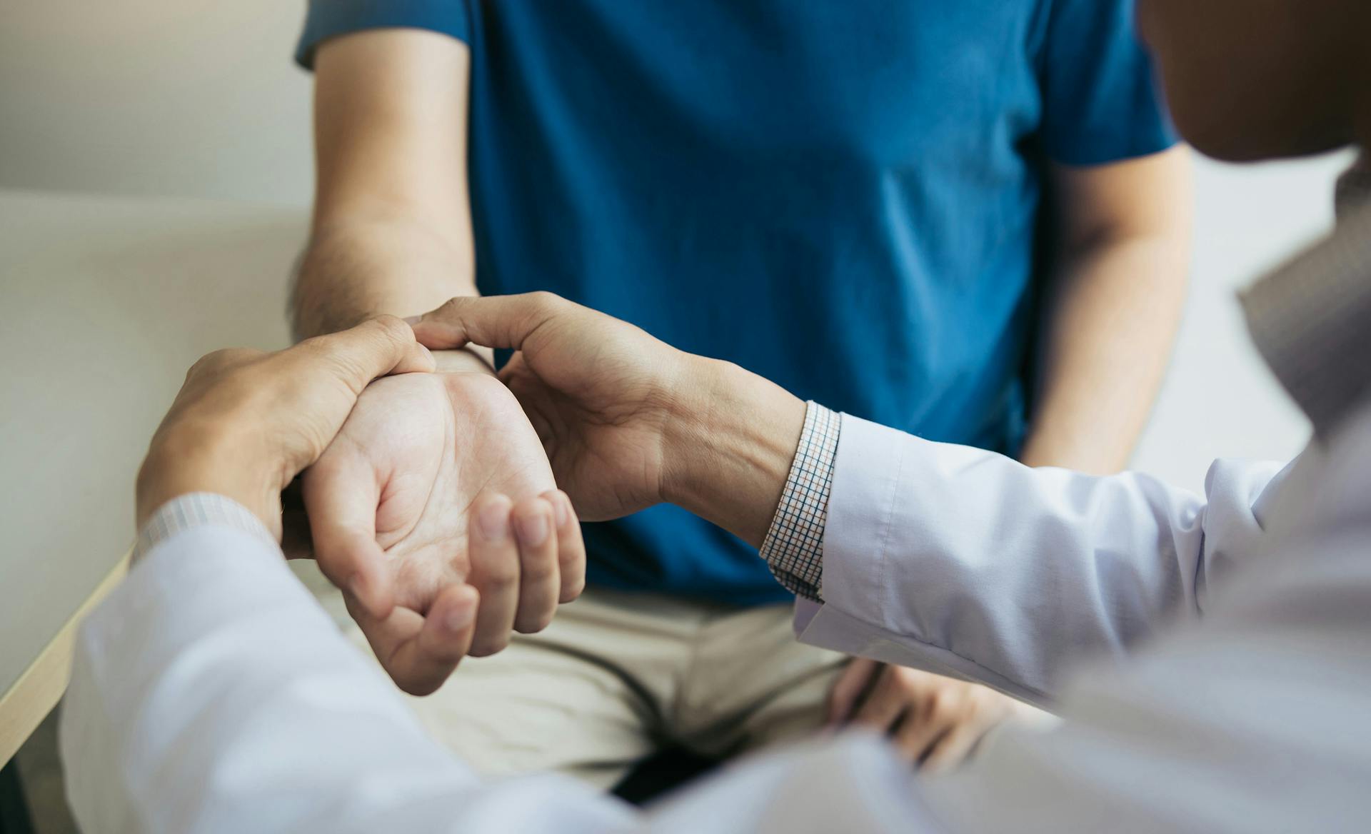 doctor checking wrist of patient