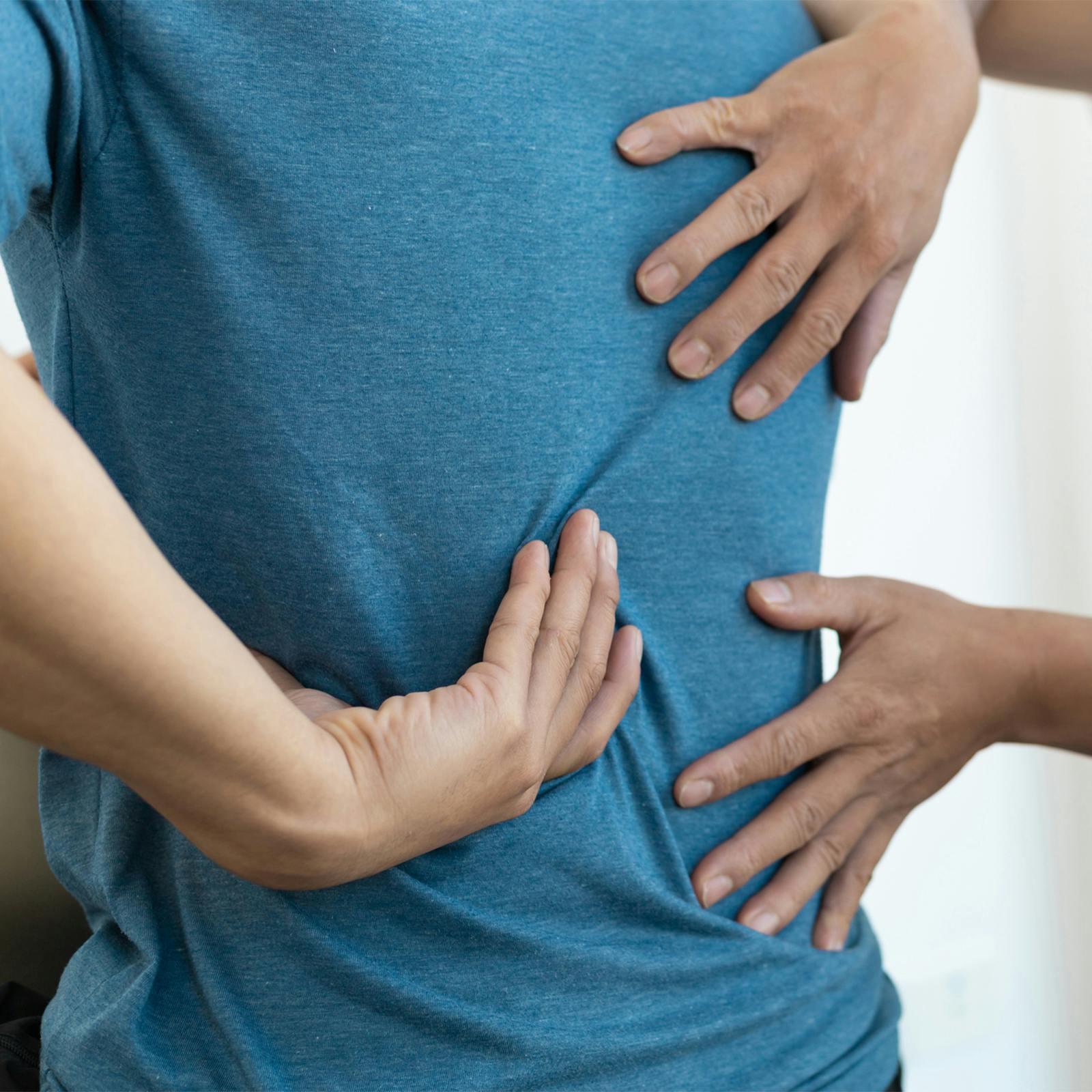 patient demonstrating where pain is on back
