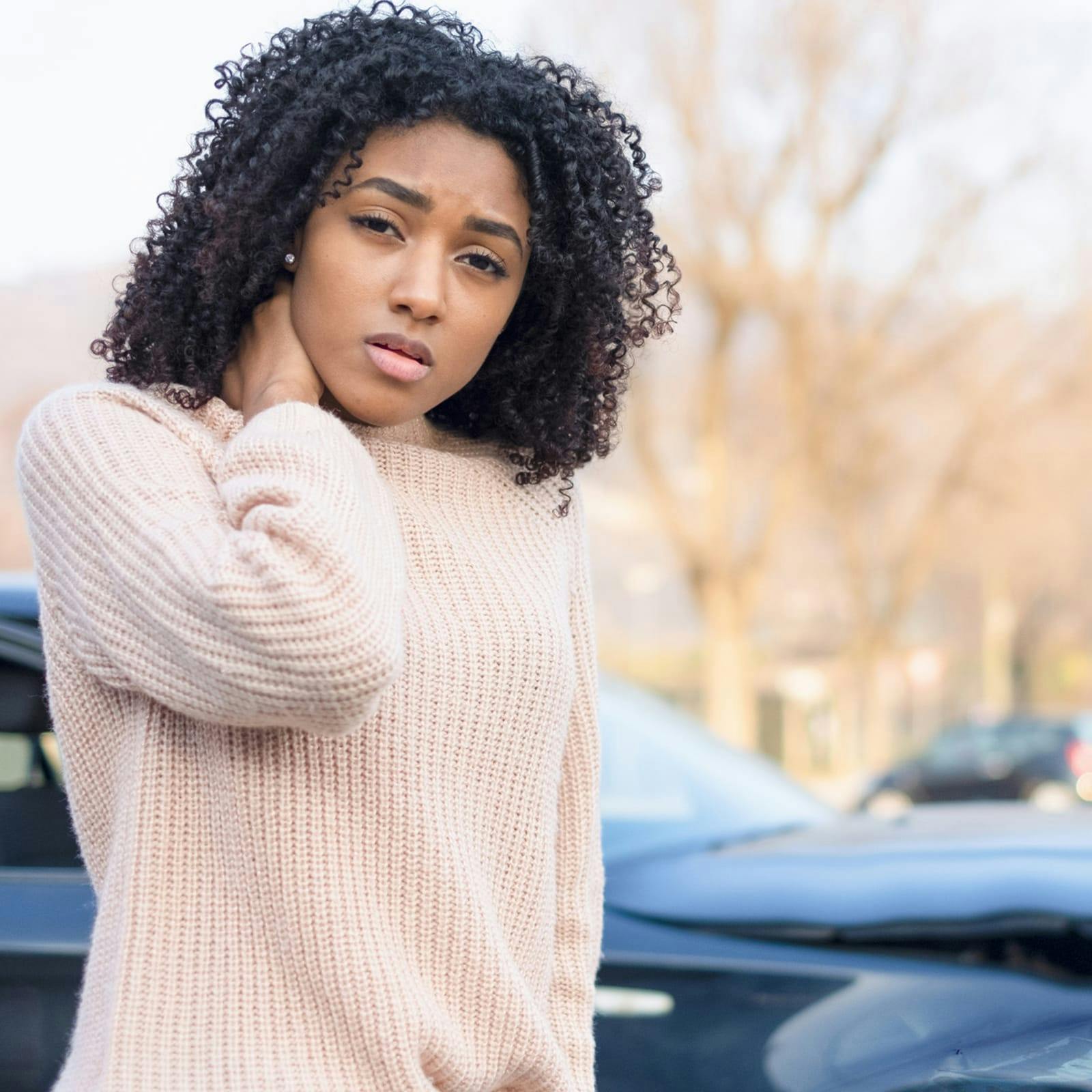 person holding neck in front of car