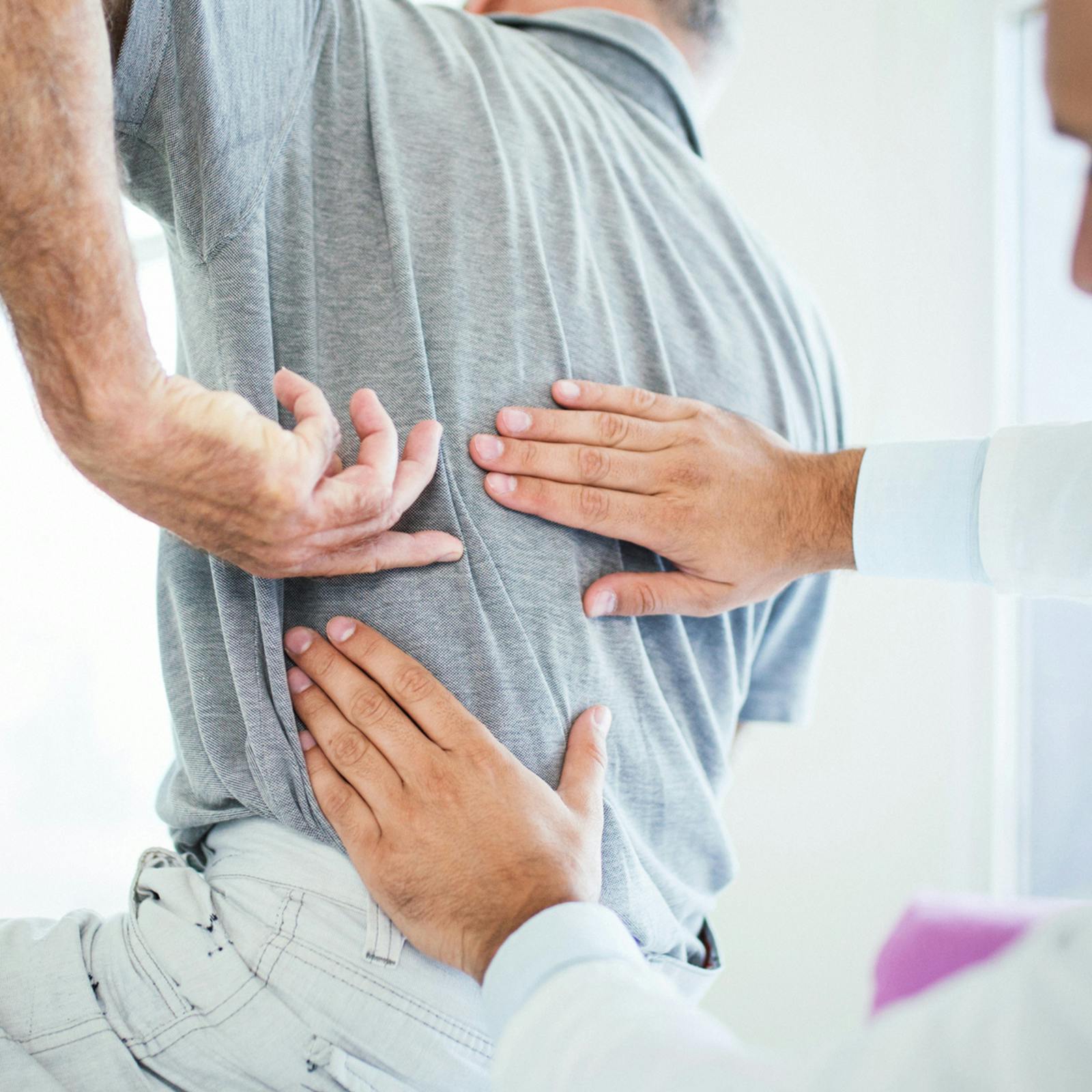man having back examined by a doctor