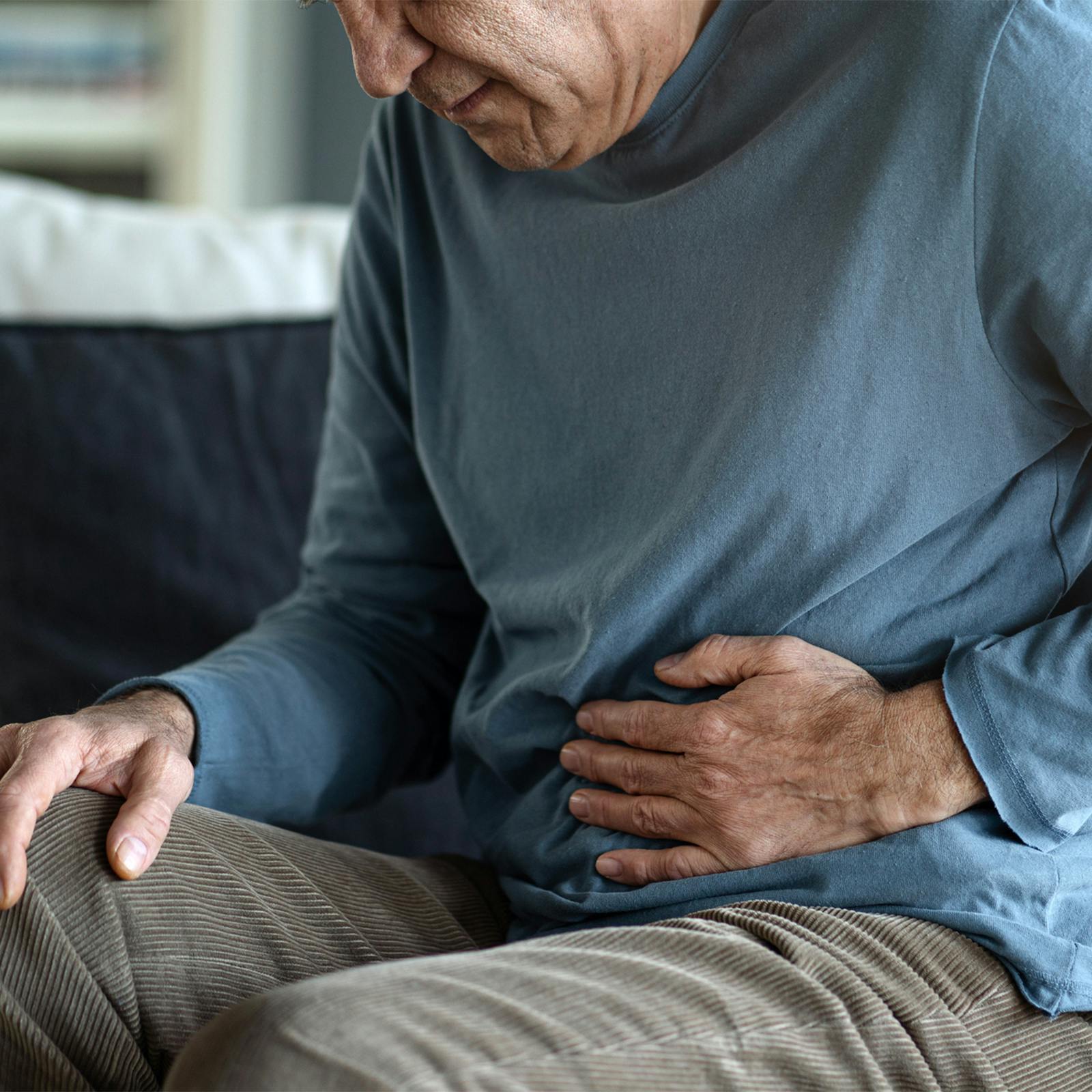 person holding stomach in discomfort