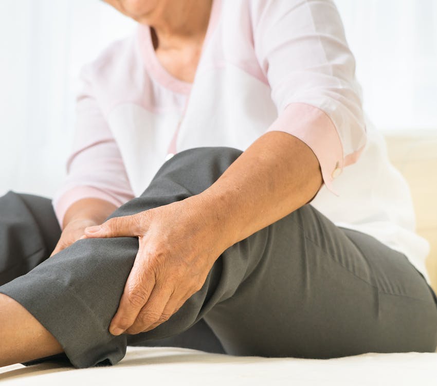 person holding their leg in discomfort