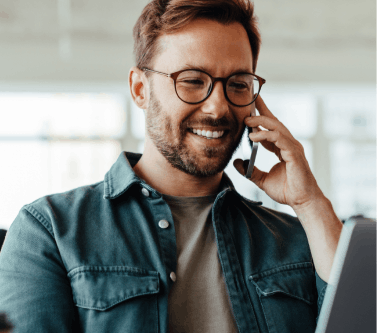 Smiling man on phone and laptop at the same time