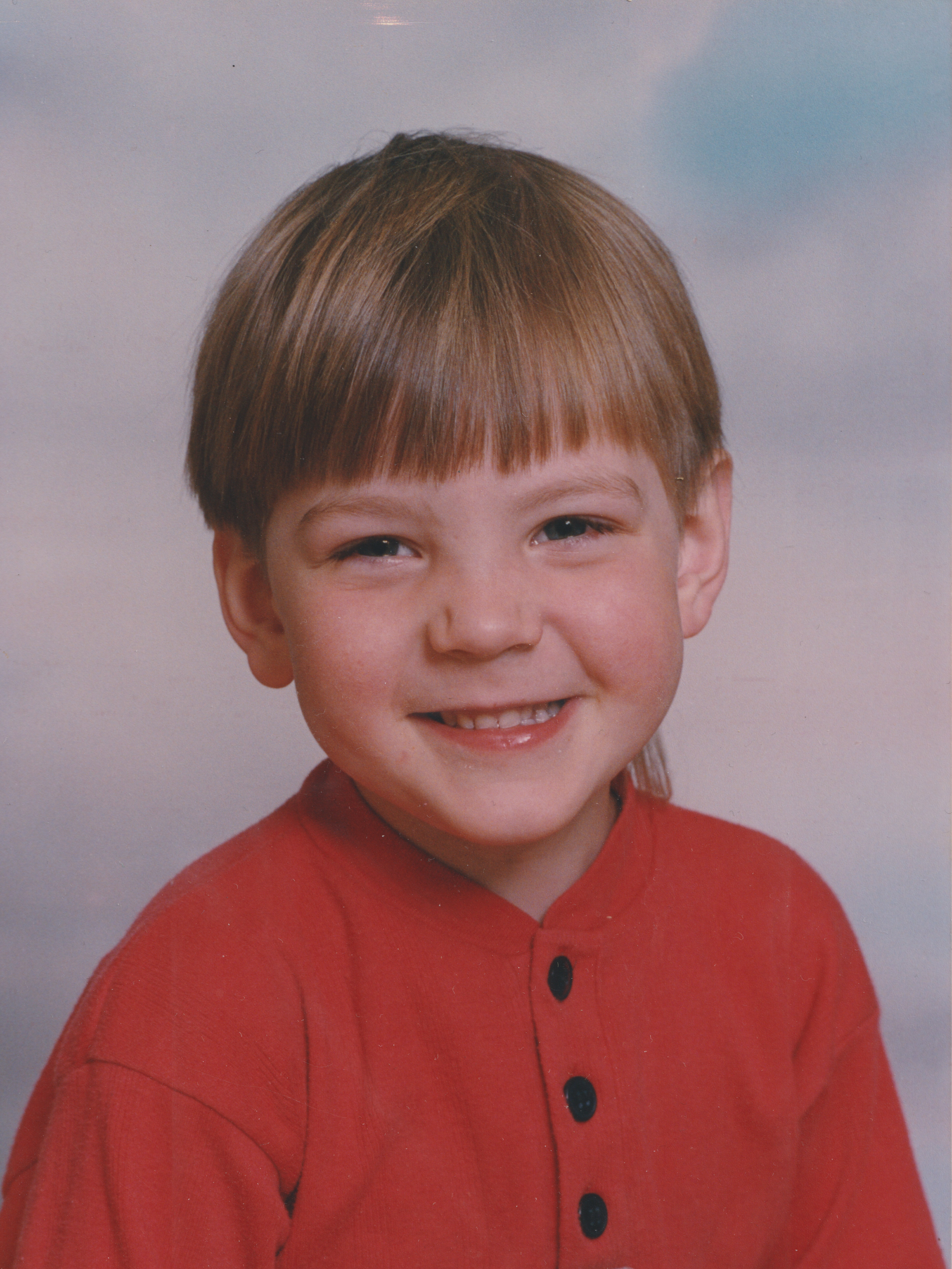 Bilden visar ett porträtt av en leende Iggy Malmborg som barn.