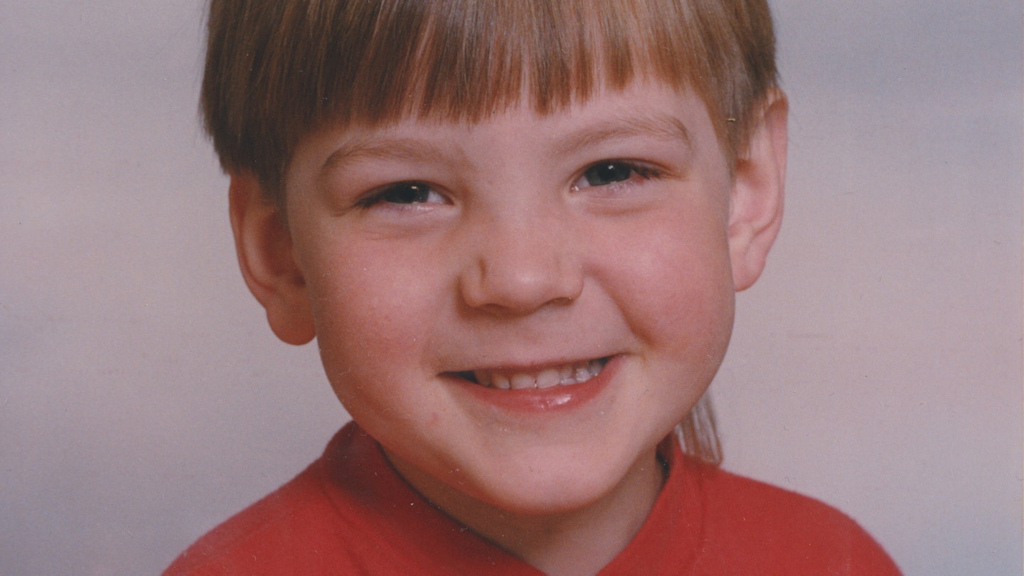 Bilden visar ett porträtt av en leende Iggy Malmborg som barn.