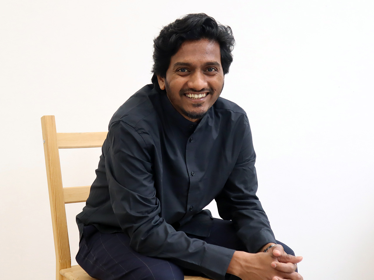 Bilden visar Amol K Patil som ler och sitter på en stol.