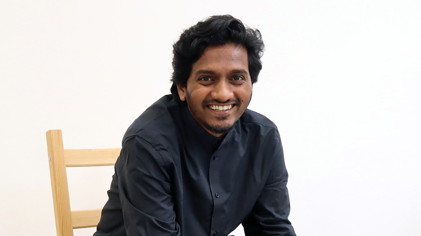 Bilden visar Amol K Patil som ler och sitter på en stol.