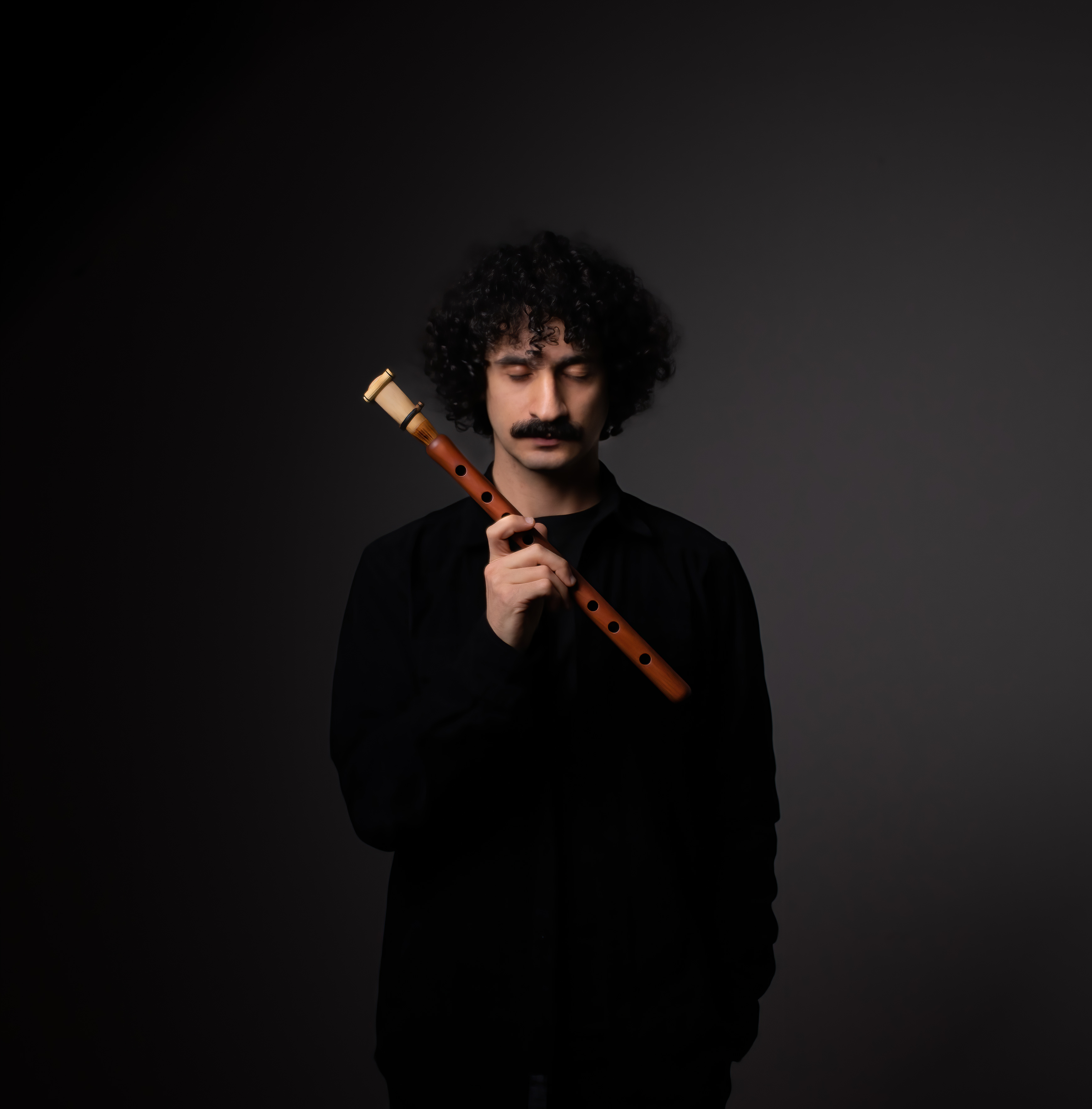 Bilden visar Canberk Ulaş som blundar med och håller i en duduk.