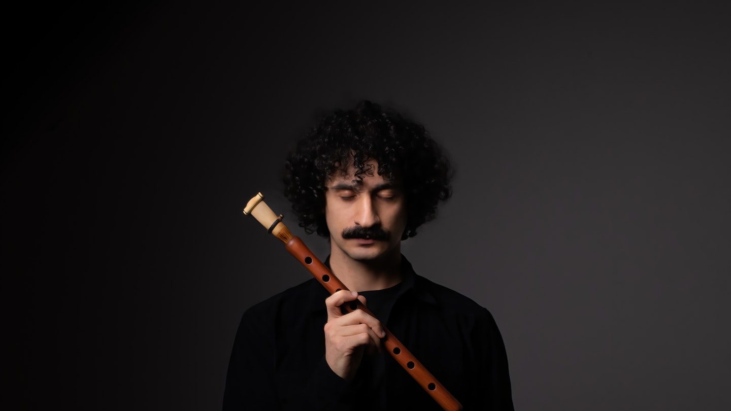 Bilden visar Canberk Ulaş som blundar med och håller i en duduk.