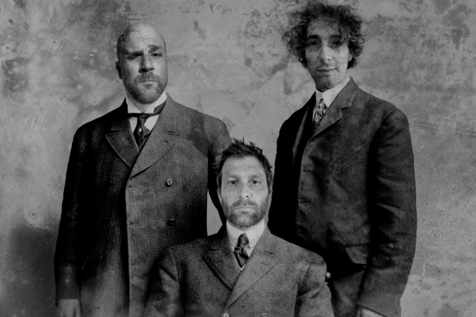 Svartvit bild som visar tre kostymklädda personer.