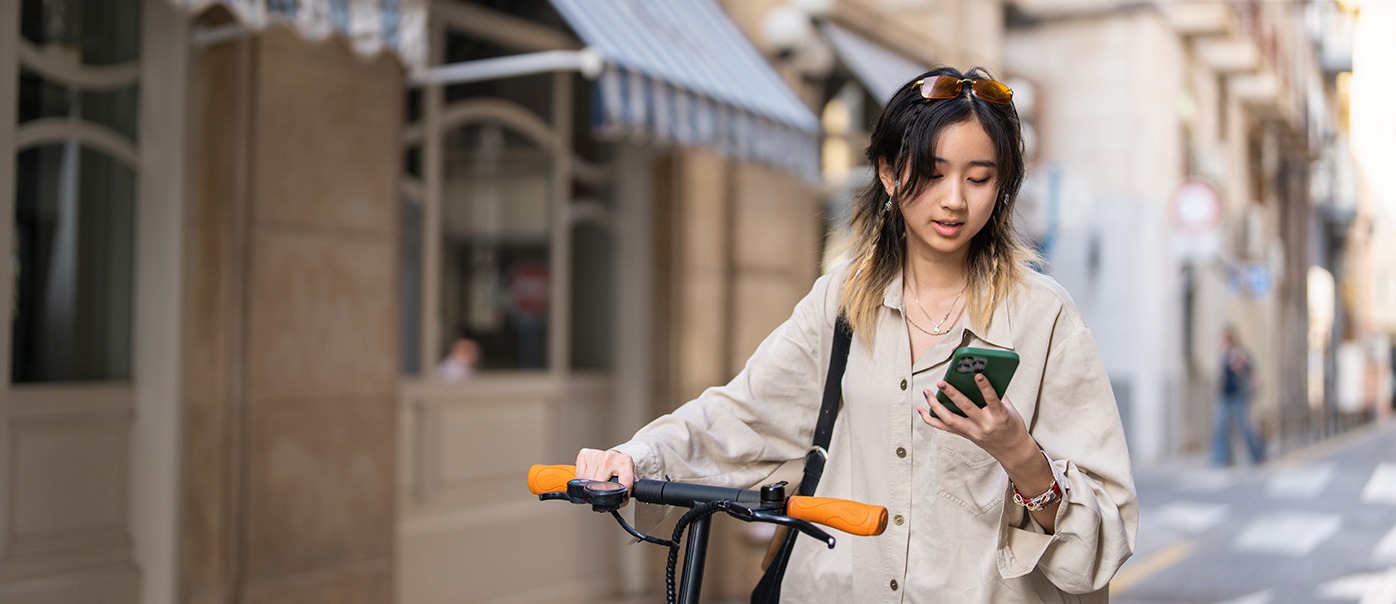 A woman with a bike looking at her mobile phone