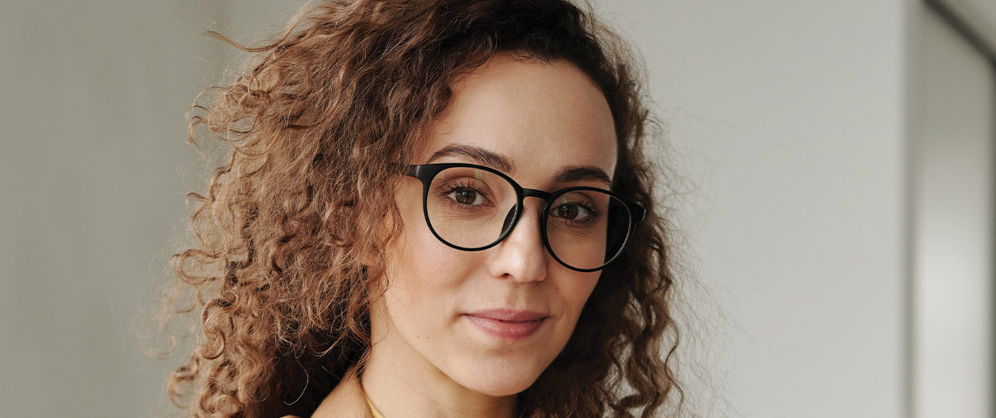 Woman with curly hair and glasses
