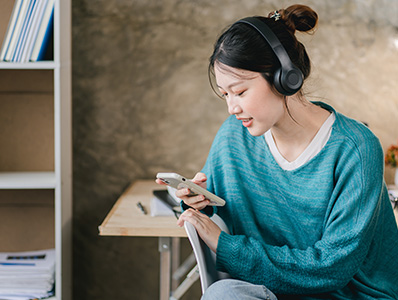 Woman in green jumper listening to music