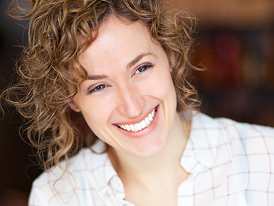 Woman with curly brown hair smiling