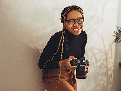 Woman holding a camera smiling