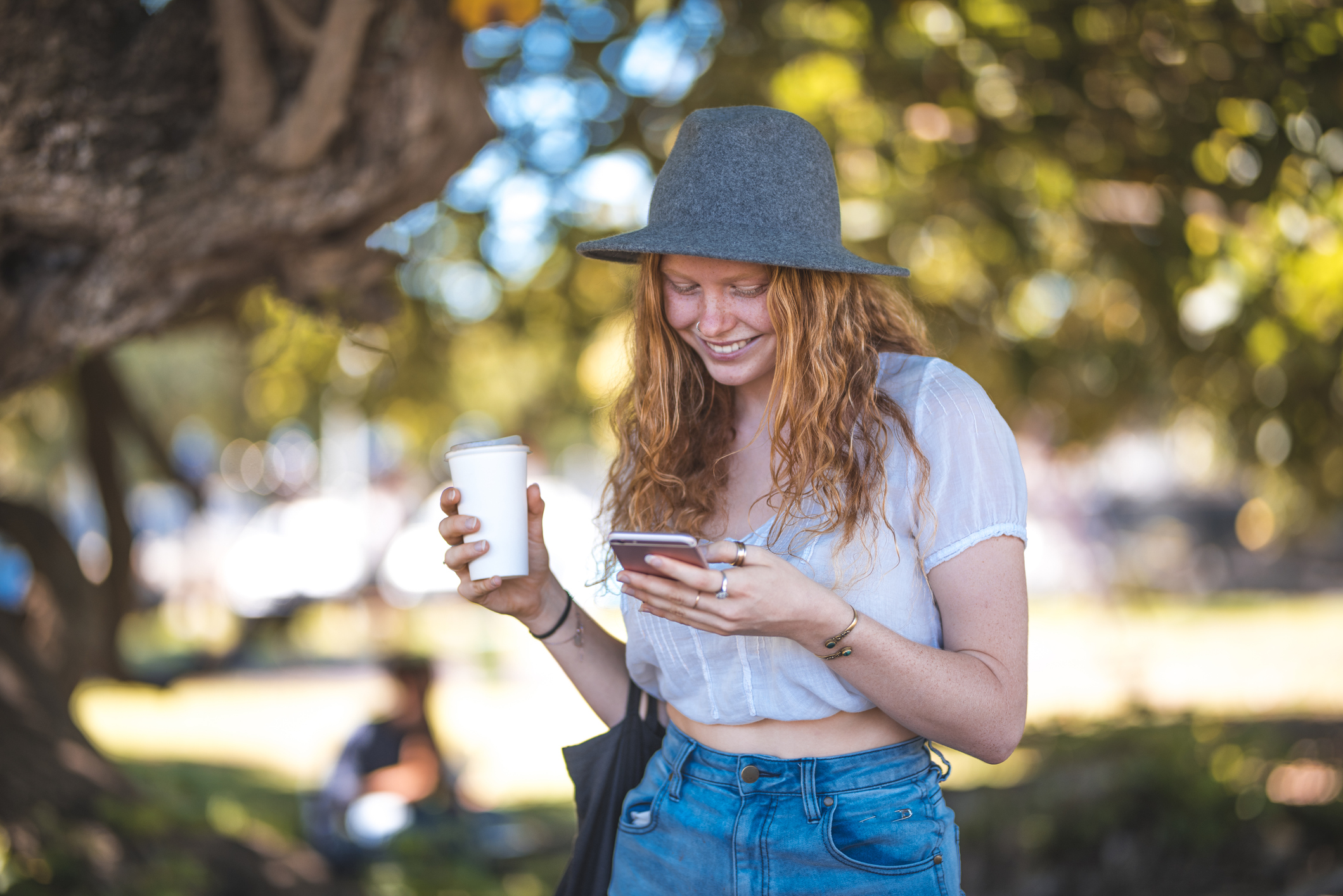 Women looking at phone while holding coffee