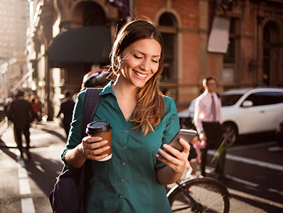 Woman crossing a street while looking at phone