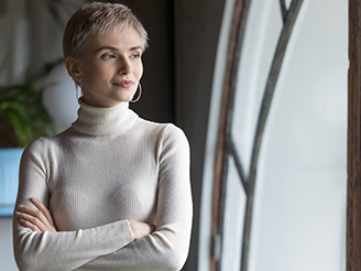 Woman wearing white turtleneck jumper looking out the window