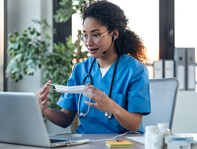 Women in hospital scrubs holding a mask