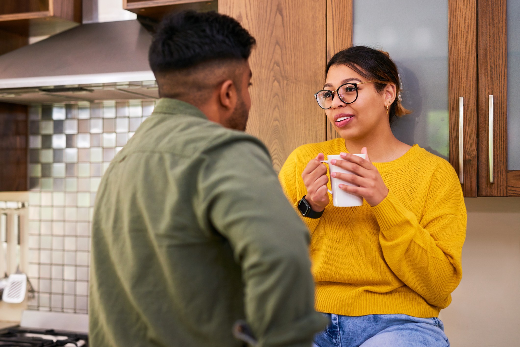 Man and women in kitchen chatting