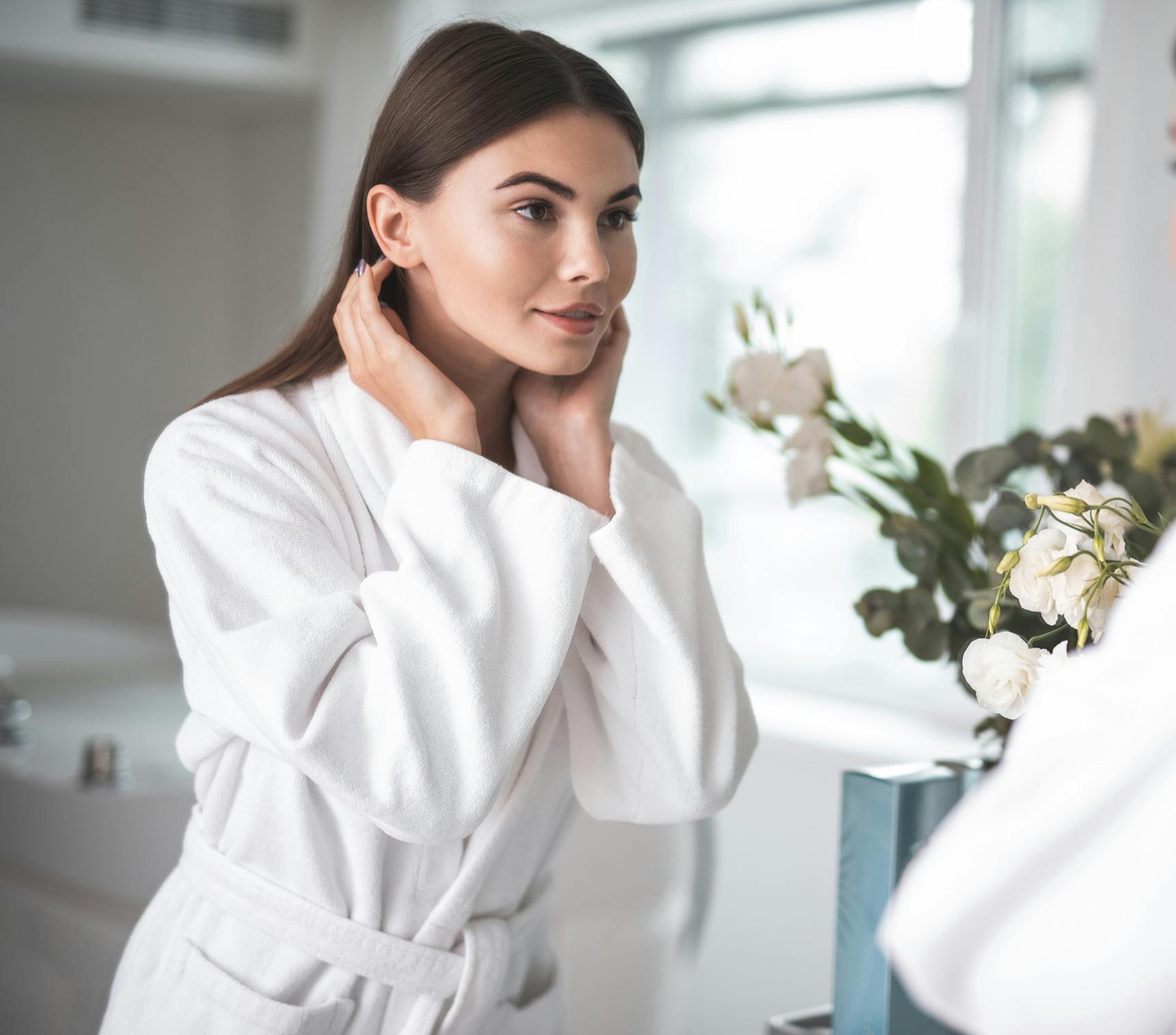 woman looking at her face in mirror