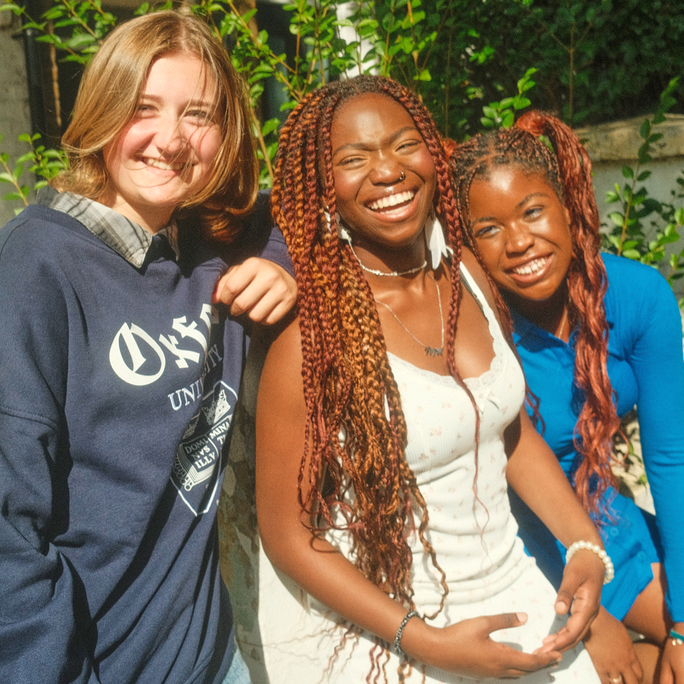 group of 3 teen girls smiling at a camera on a summer's day