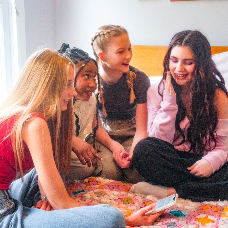 teens gathered around looking at luna app