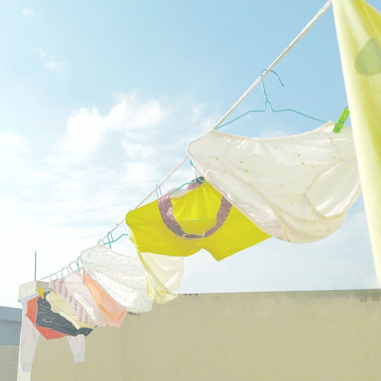 Underwear hang drying on an outdoor washing line against a blue sky.