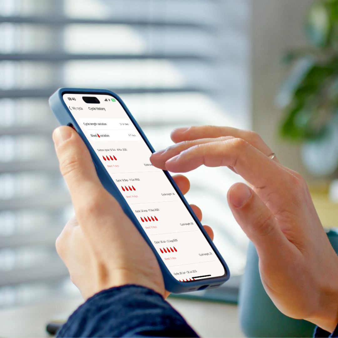 Hands holding a phone showing a cycle history screen with past period dates and durations listed.