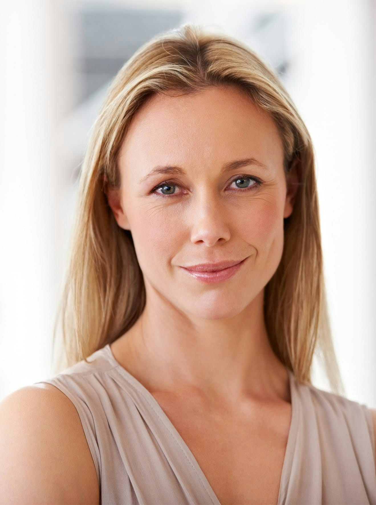 close up of woman in tan dress smiling