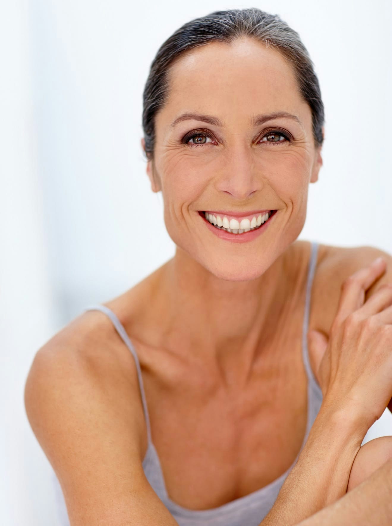 Woman in grey tank top smiling