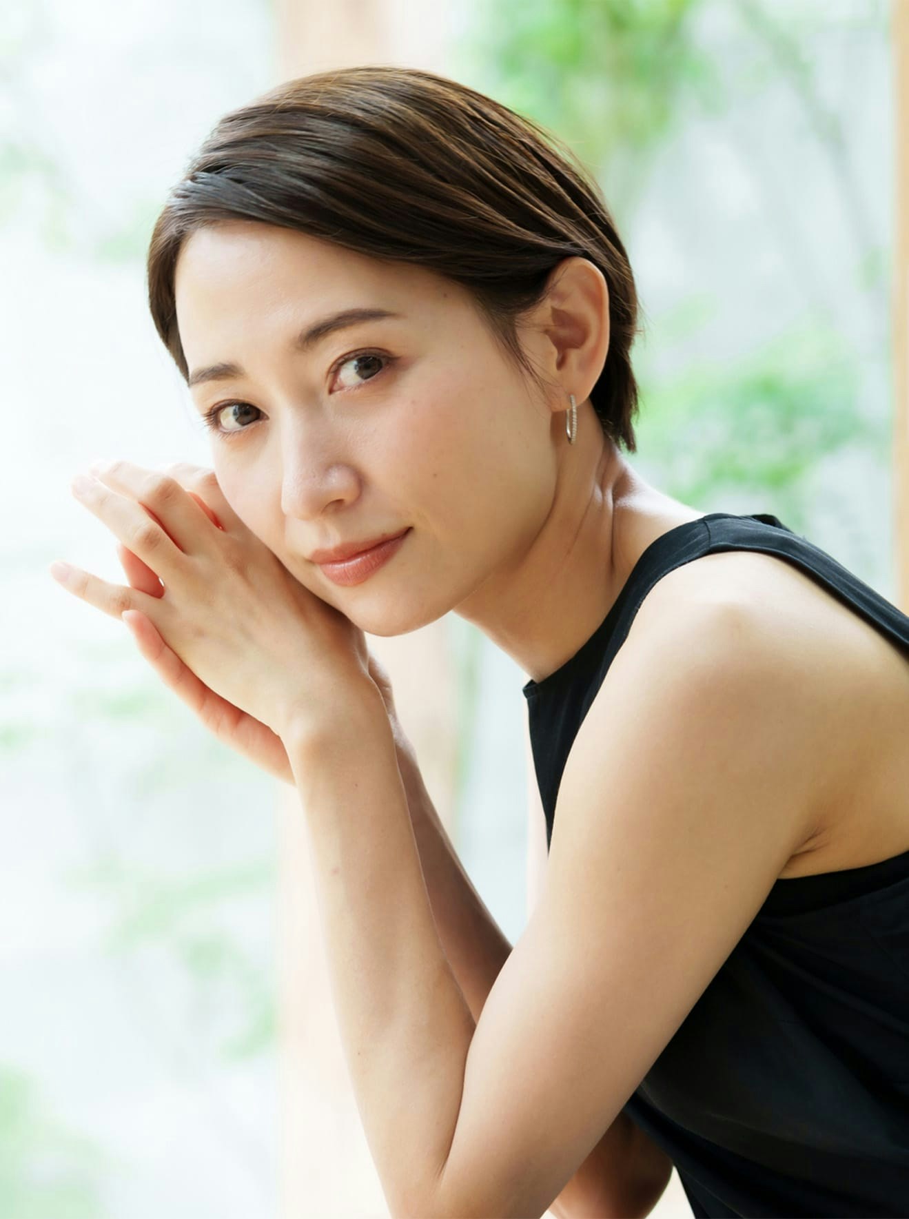 Woman in black tank top leaning on railing