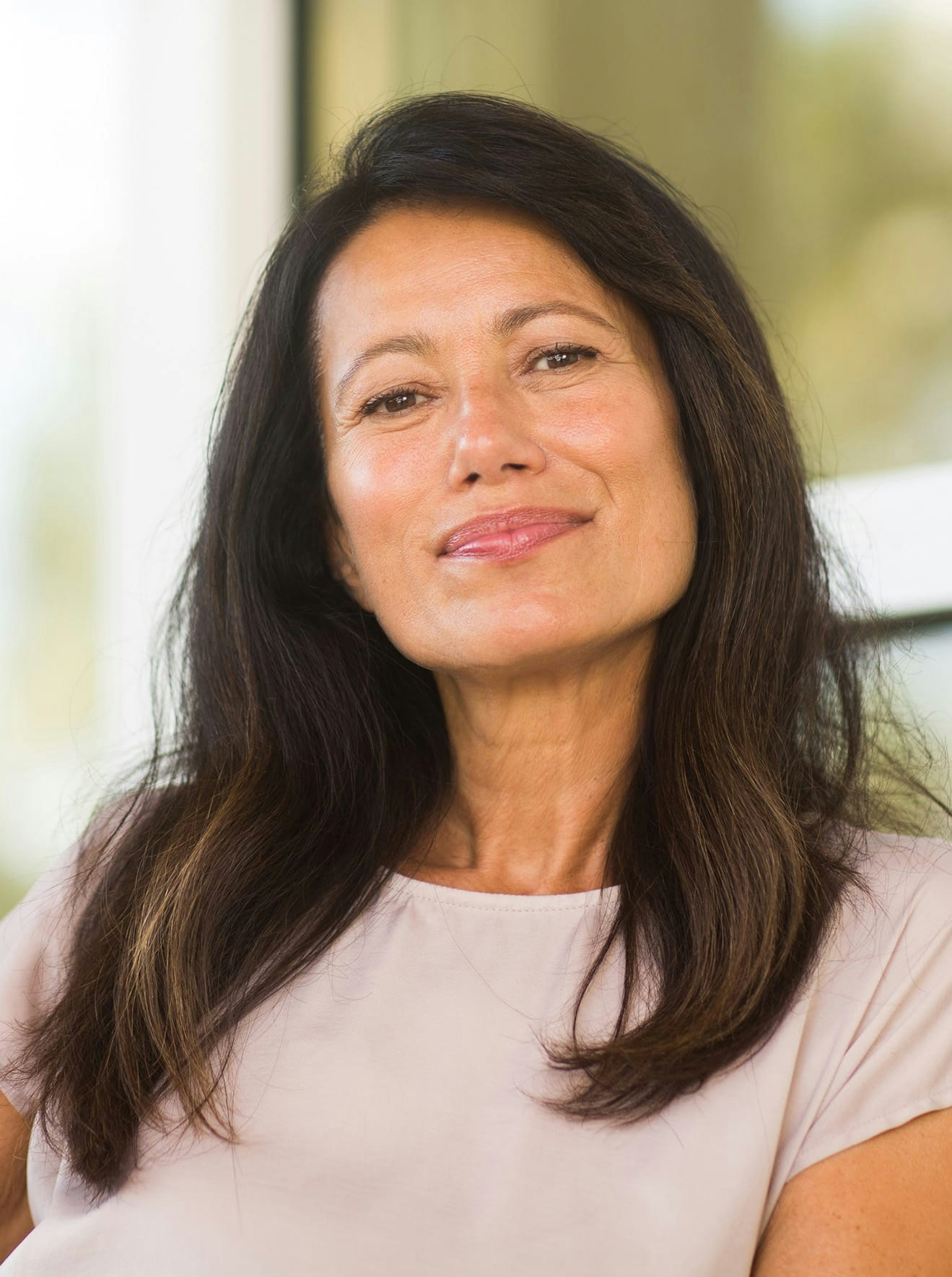 Woman in tan blouse smiling
