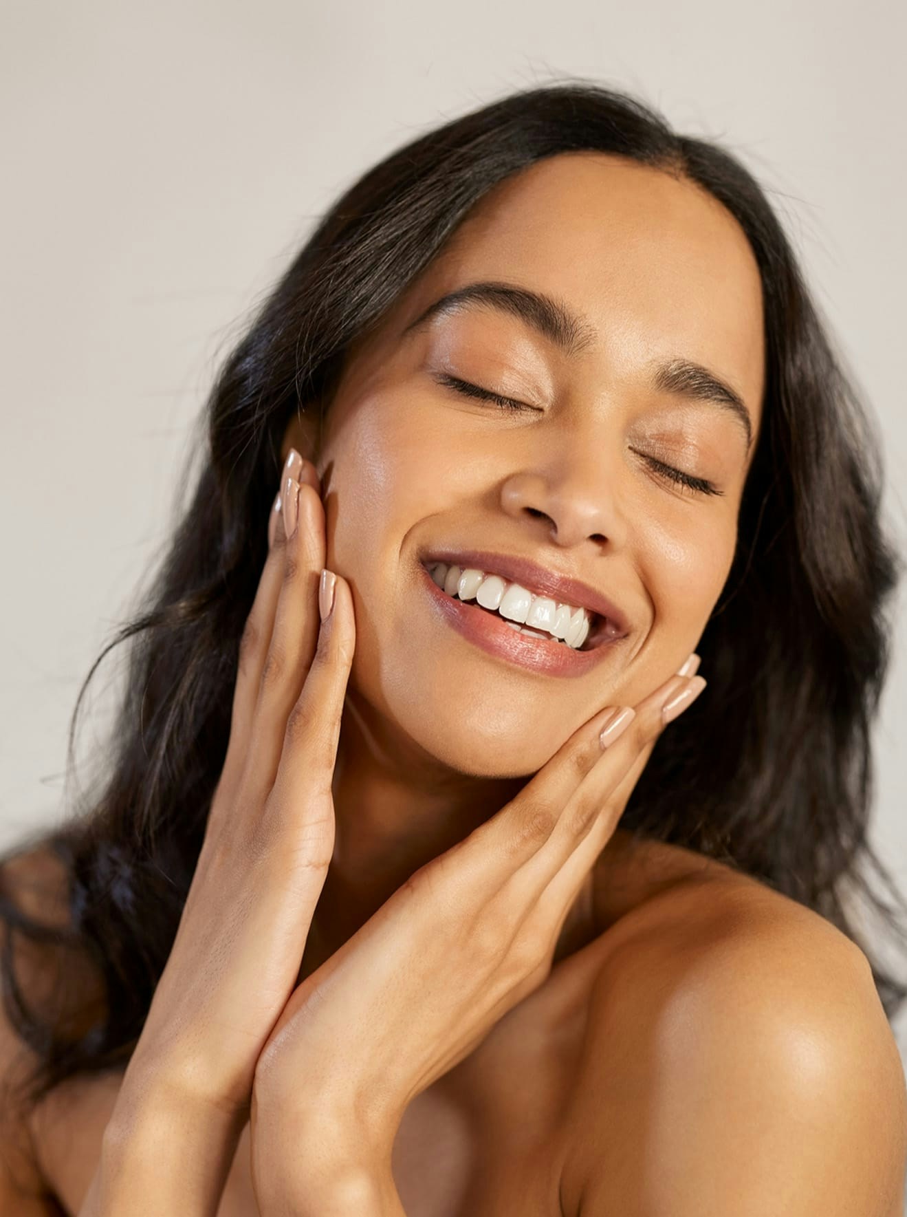 Woman smiling and touching face