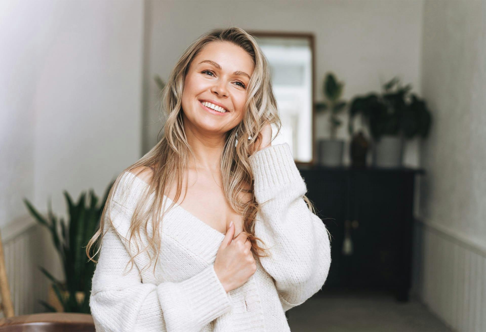 Woman in white sweater smiling