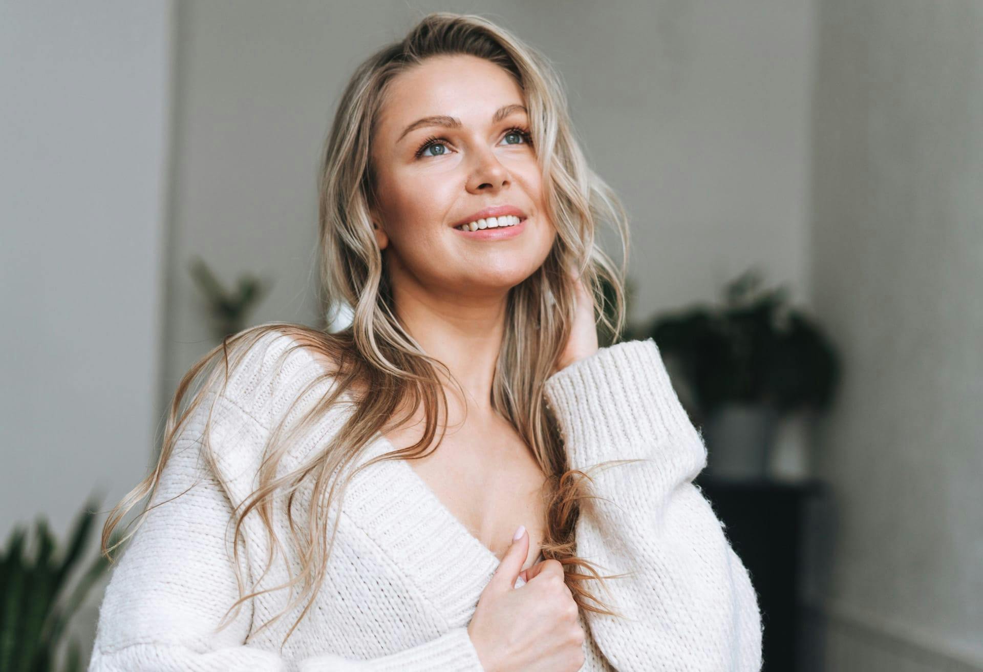 Close up of woman in white sweater smiling