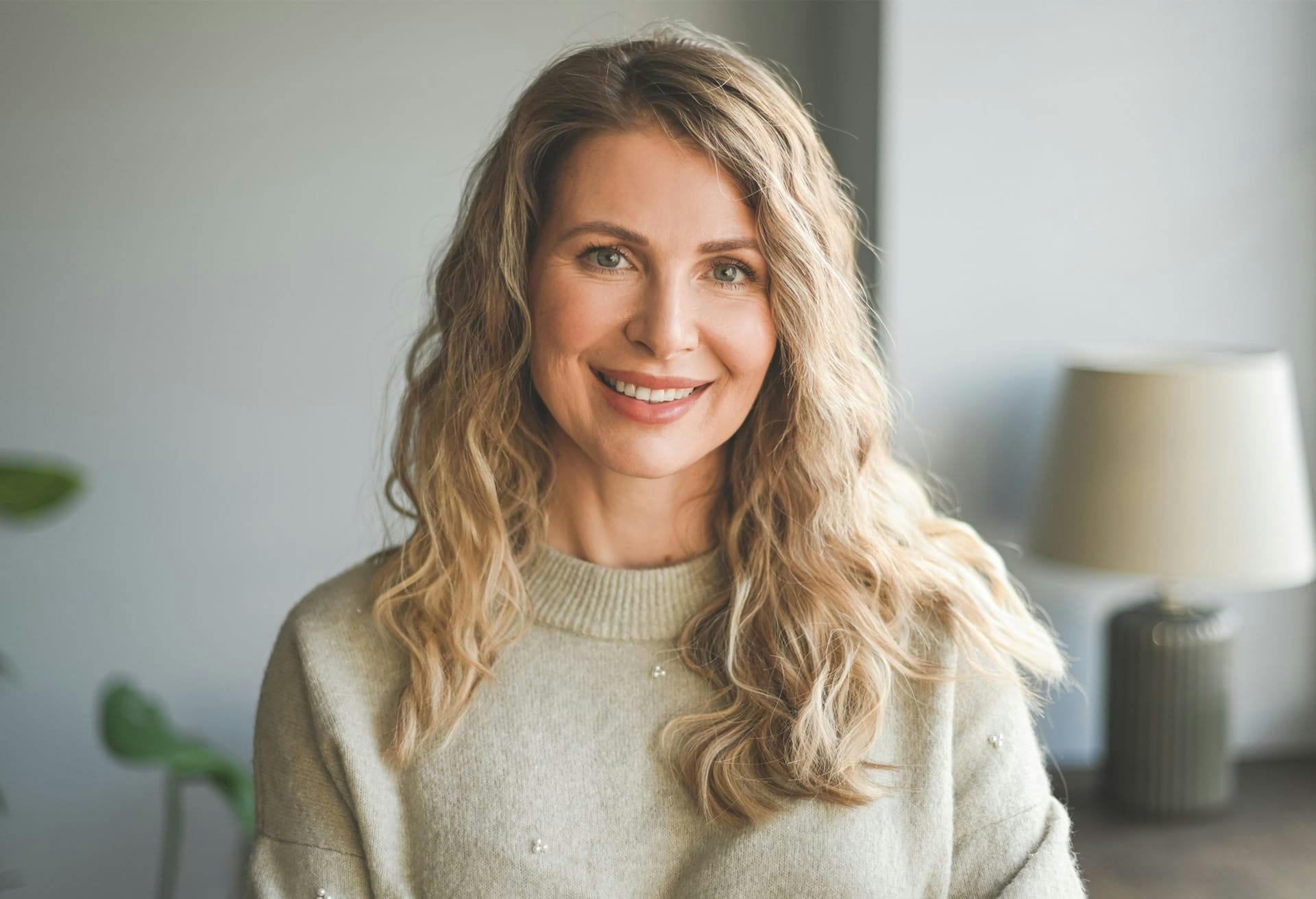 Woman in tan sweater smiling