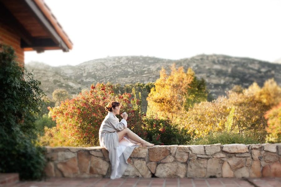 Woman sitting on stone wall at Rancho La Puerta