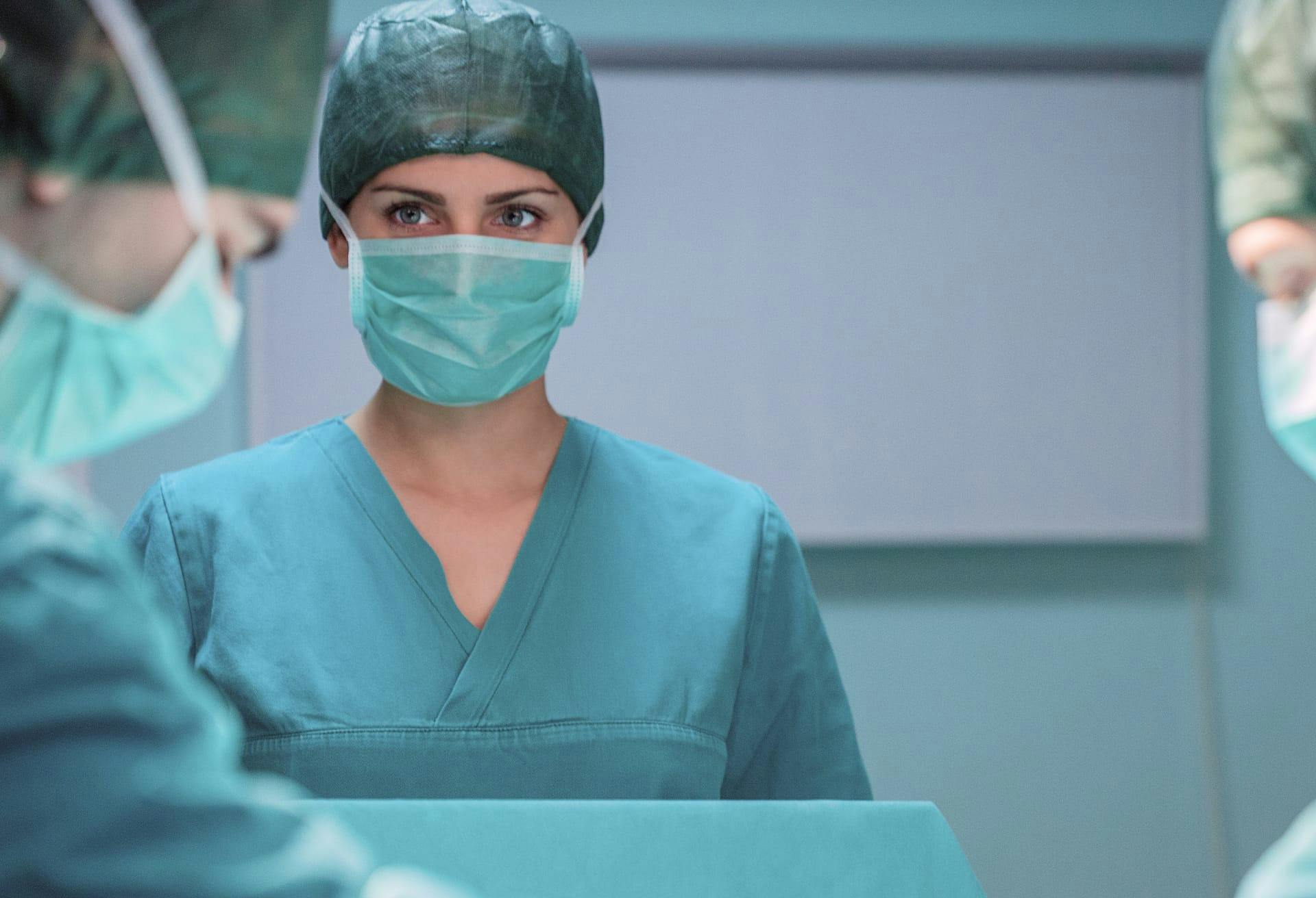 Woman doctor in scrubs performing surgery