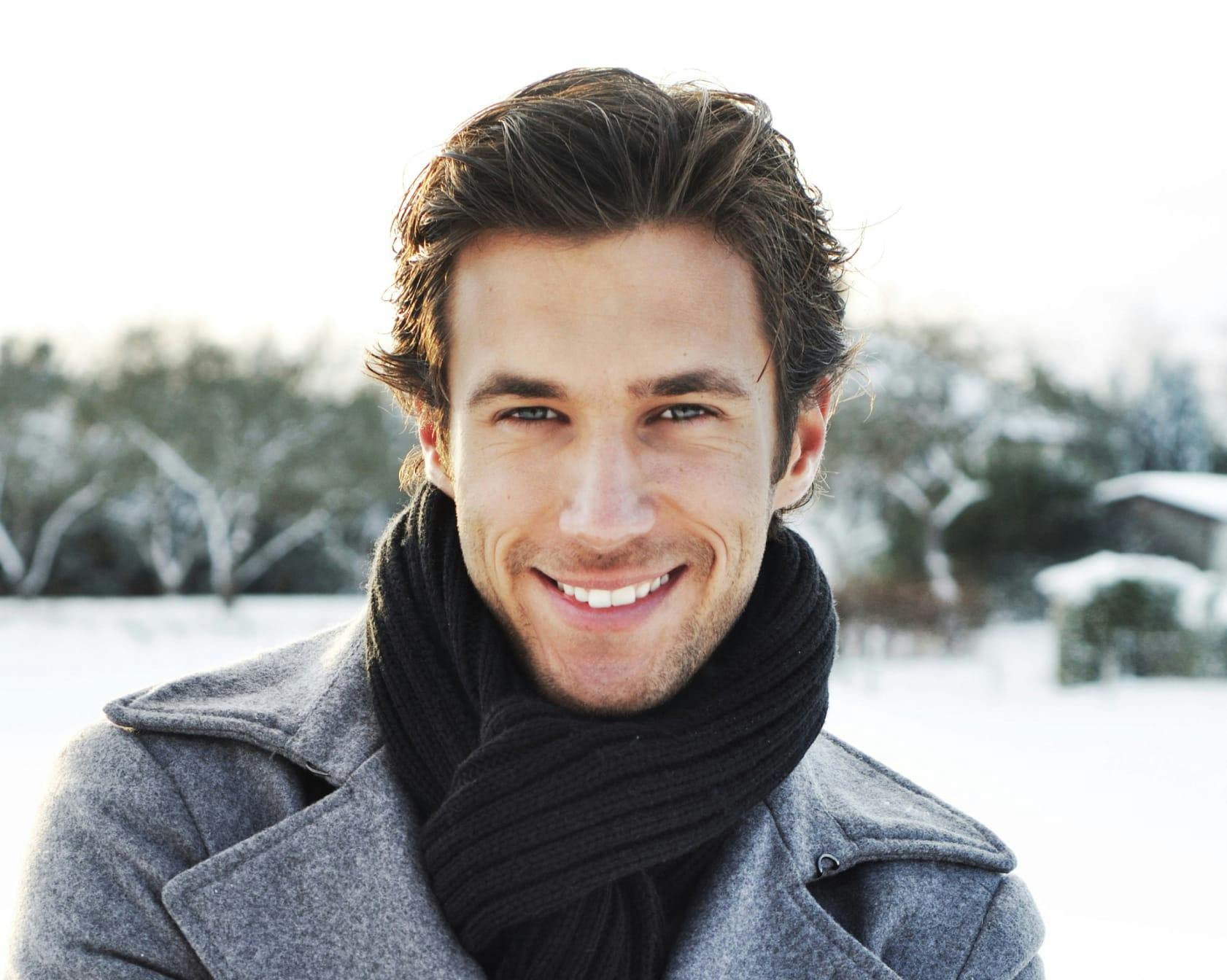 Man smiling in outside in the snow.