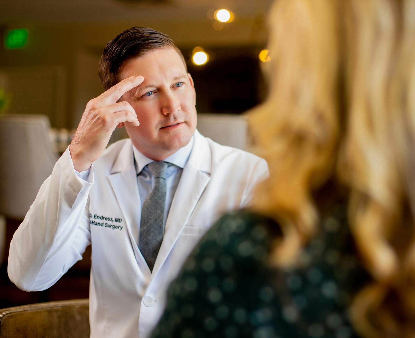 blond woman in a green dress looking at Dr. Ryan Endress