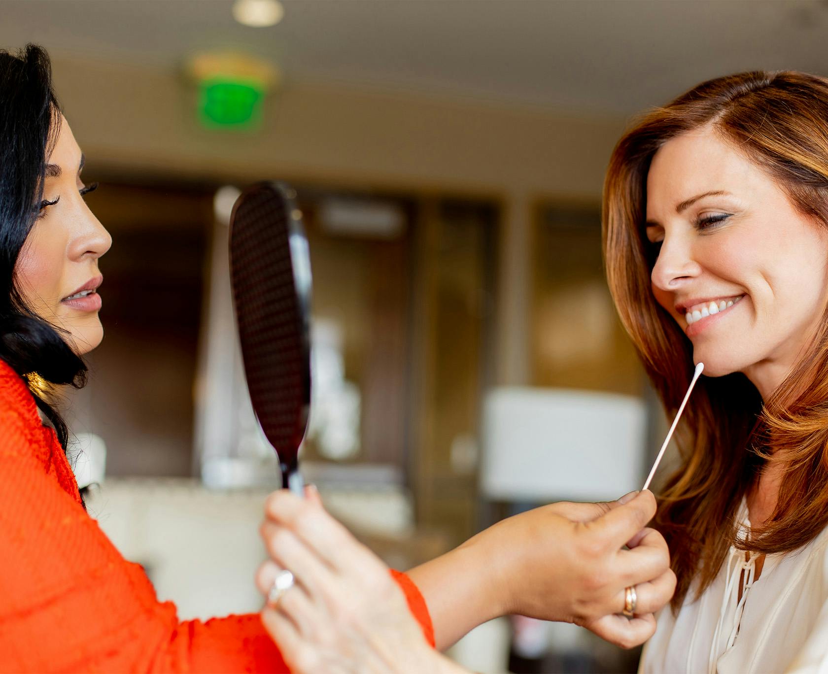 Dr. Lily Daniali with a patient looking at face in mirror and smiling