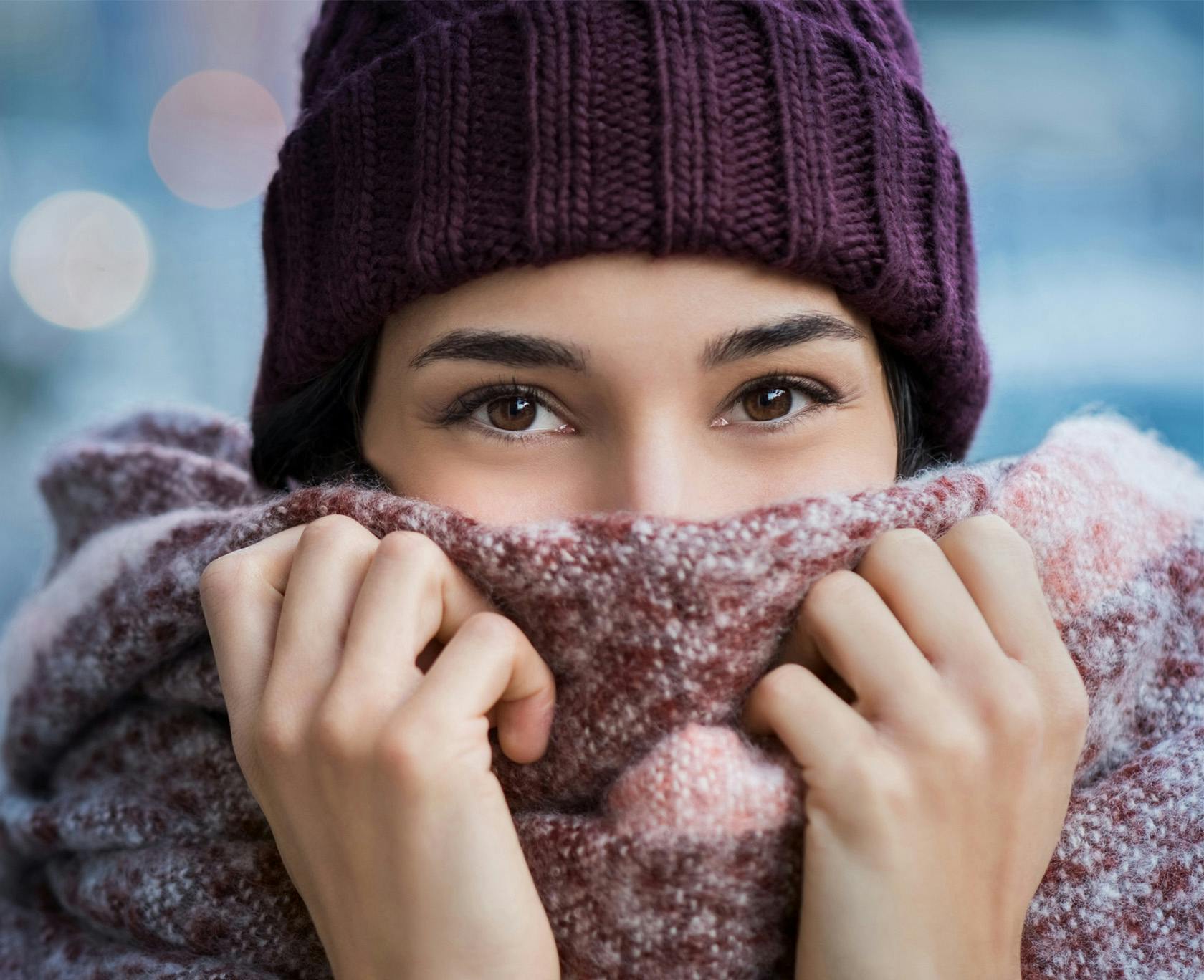 woman wearing a purple hat and scarf covering her face