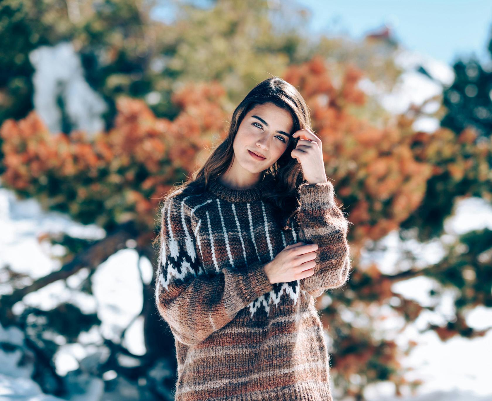 woman in a hat and sweater posing for a picture