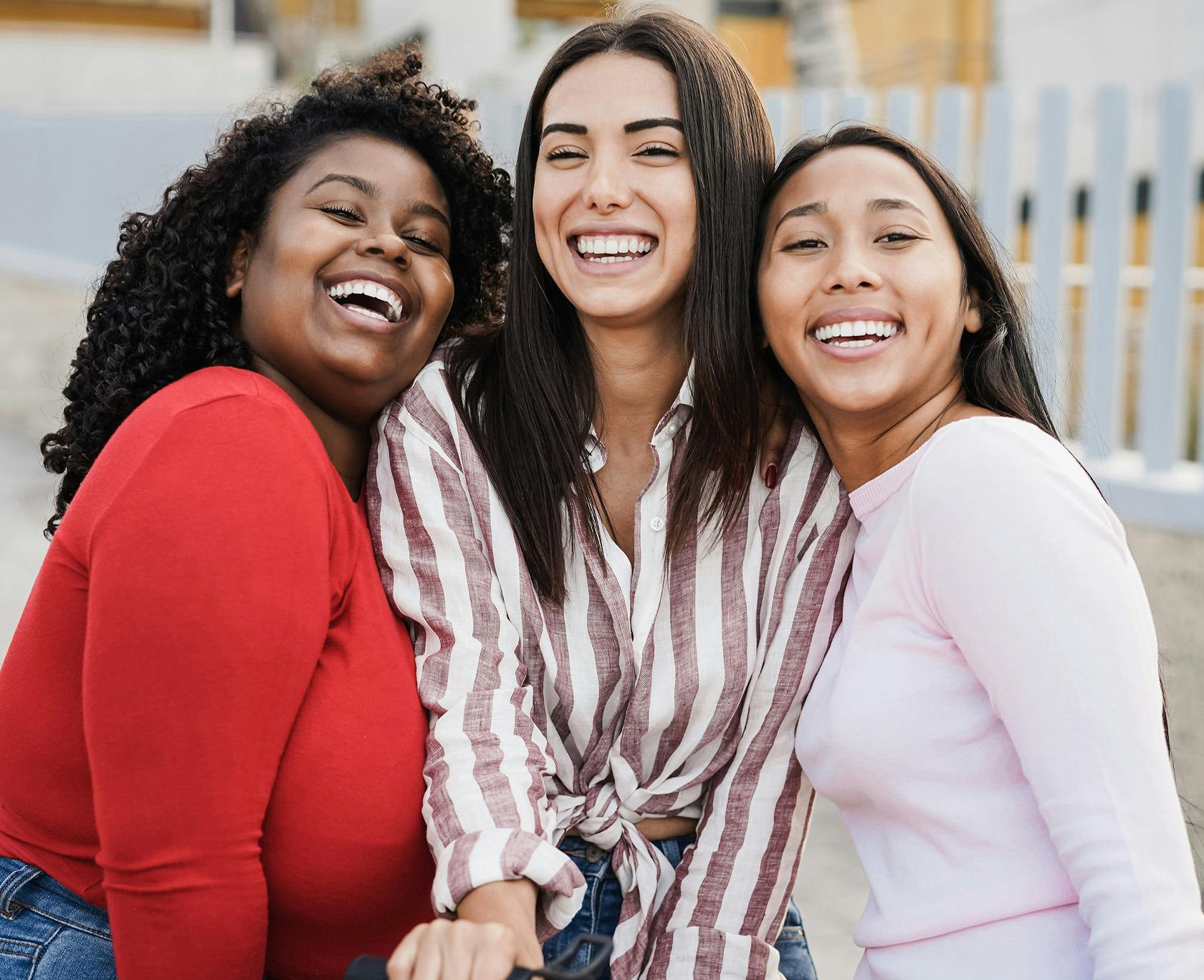 three women are smiling and posing for a picture together