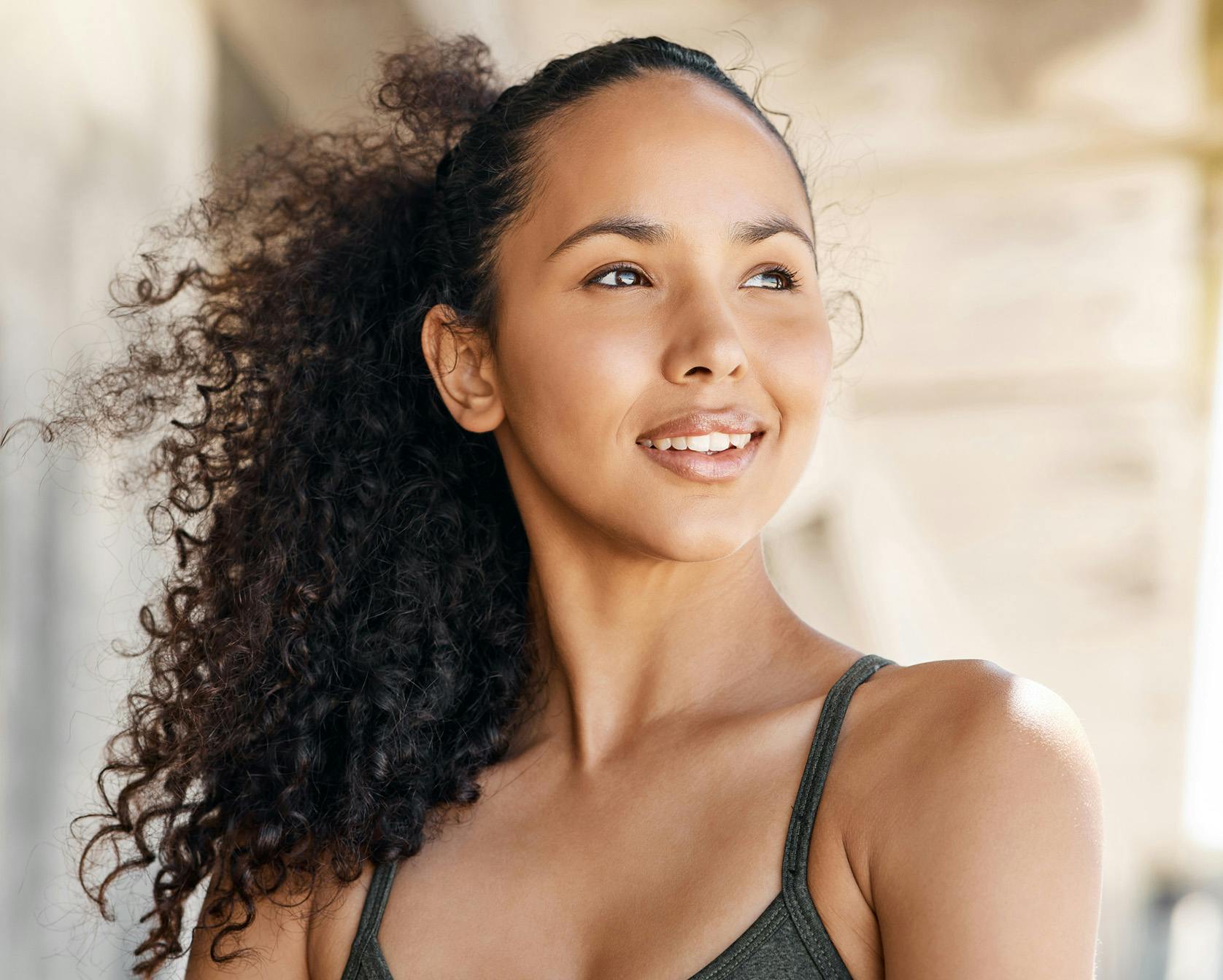Woman with curly brown hair smiling