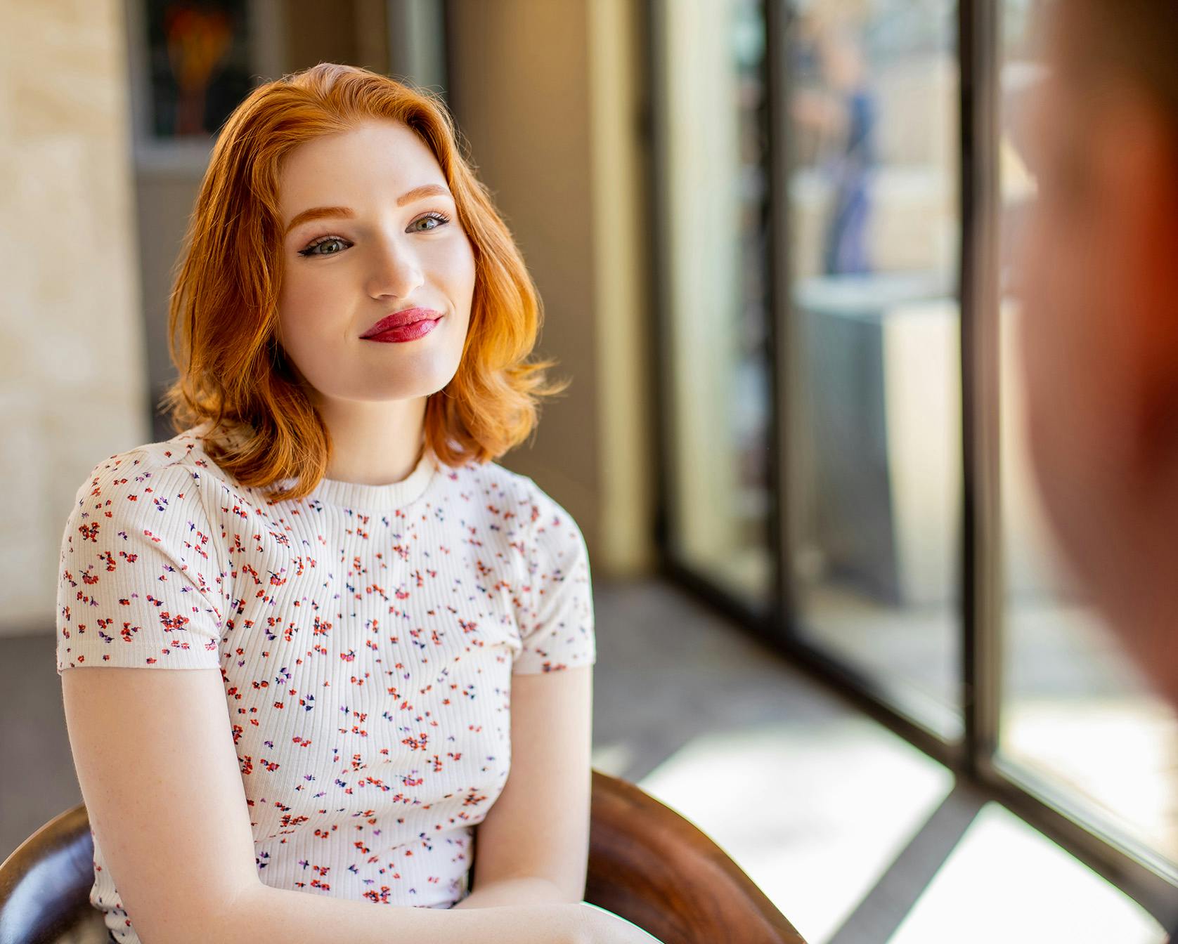Redheaded woman sitting in a chair