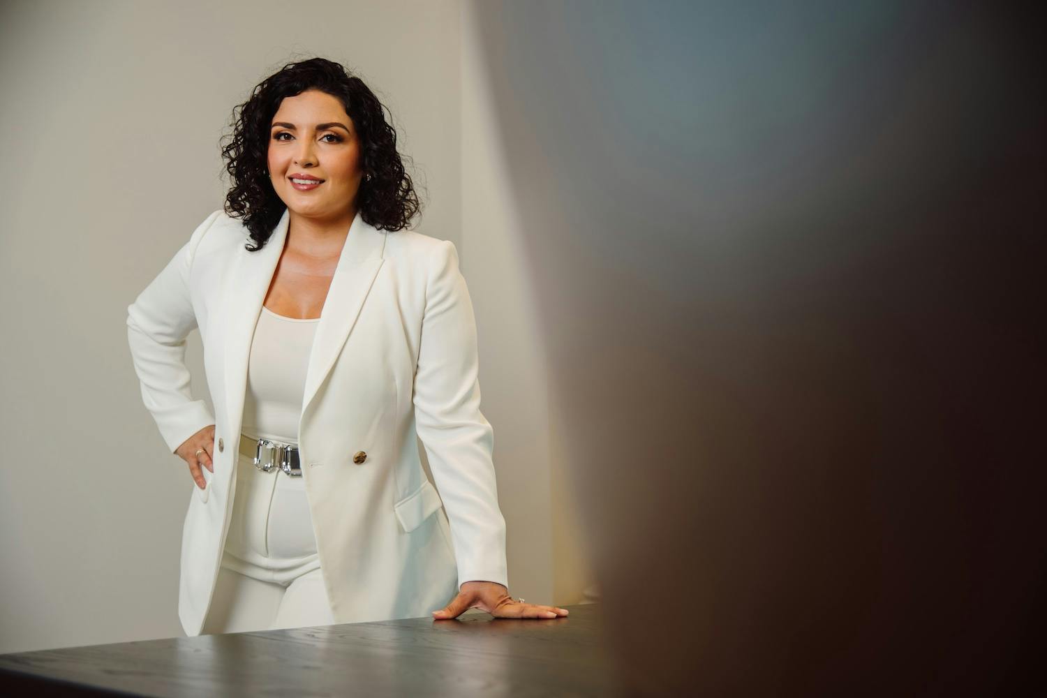 Dr. Lily Daniali in white suit standing behind table